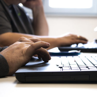 Mitarbeiter schreibt an PC Tastatur